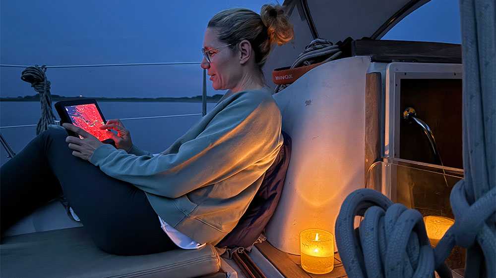 A sailor planning a route with Orca Display at dusk